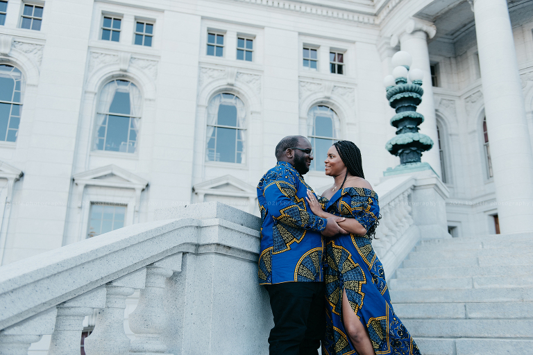 a couple perch on a grand staircase during their Madison engagement session